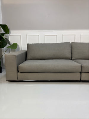 Gebrauchtes graues Minotti Hamilton Designer Stoff Sofa vor einer Wand, stilvoll und modern eingerichtet.