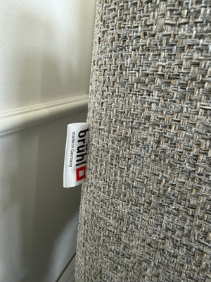 Gebrauchtes graues Brühl Alba Designer Stoff Sofa vor einer Wand, stilvoll und modern eingerichtet