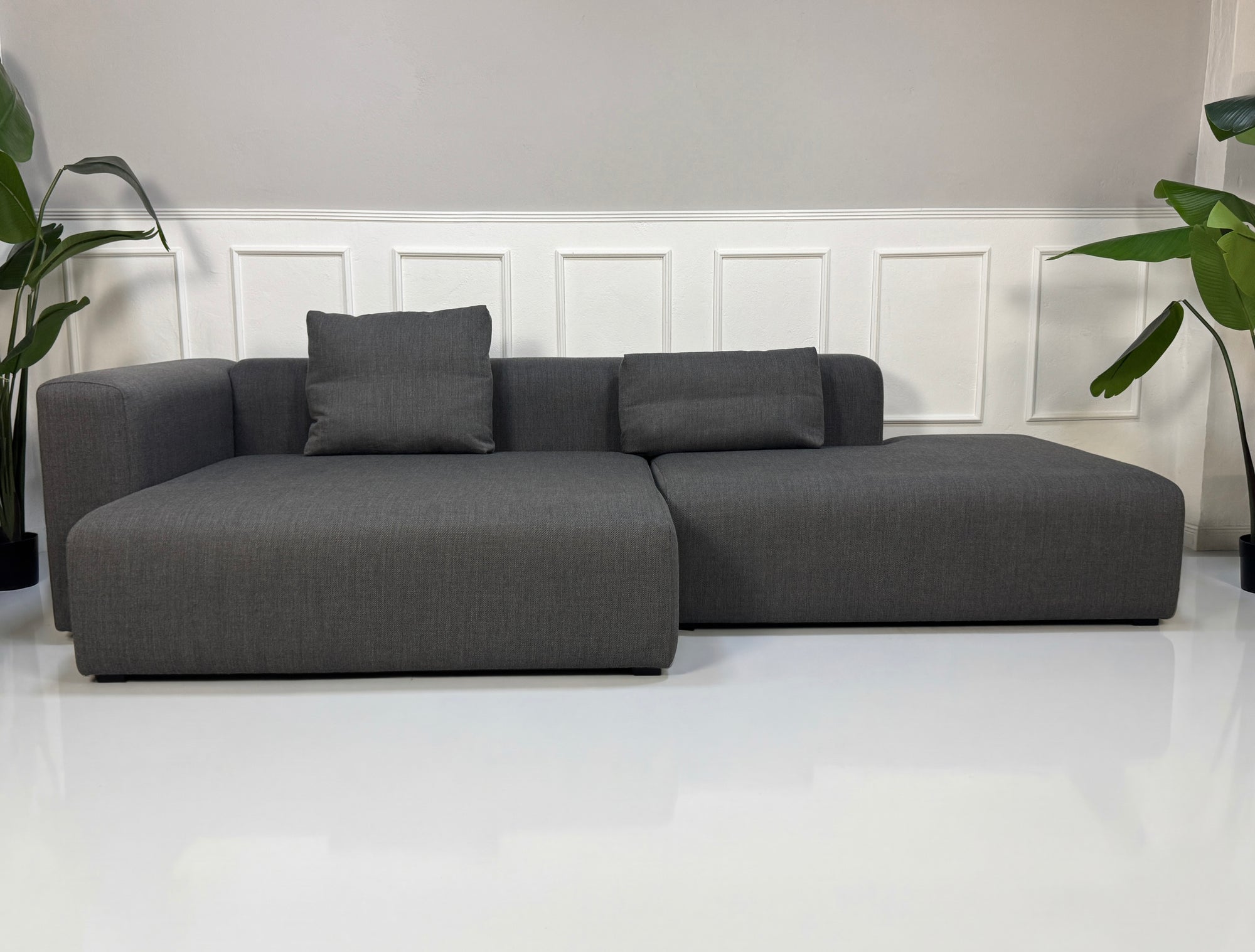 Gebrauchtes graues Hay Mags Designer Stoff Sofa vor einer Wand, stilvoll und modern eingerichtet.
