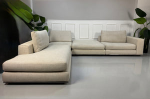 Gebrauchtes beiges Minotti Hamilton Designer Stoff Sofa vor einer Wand, stilvoll und modern eingerichtet