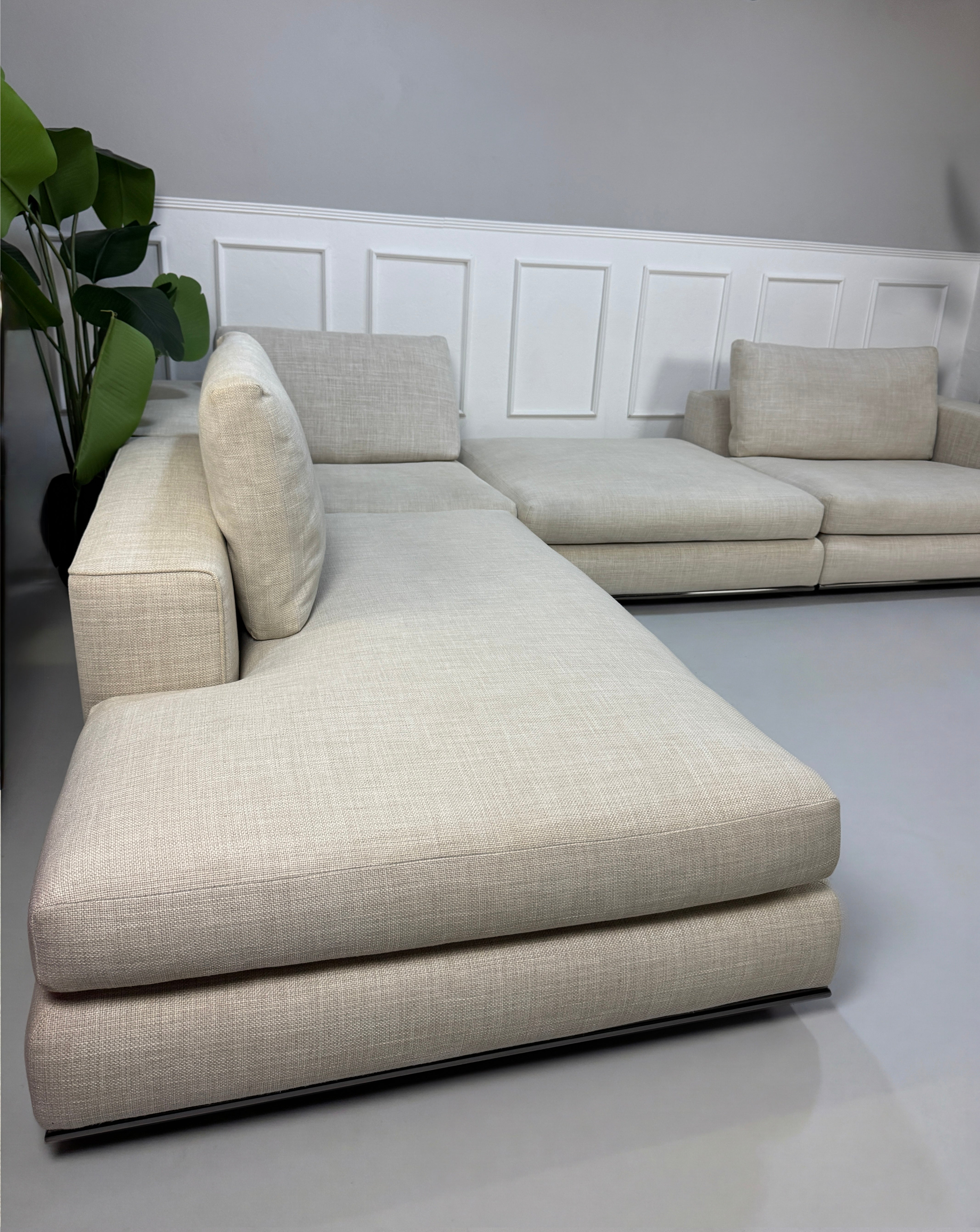 Gebrauchtes beiges Minotti Hamilton Designer Stoff Sofa vor einer Wand, stilvoll und modern eingerichtet