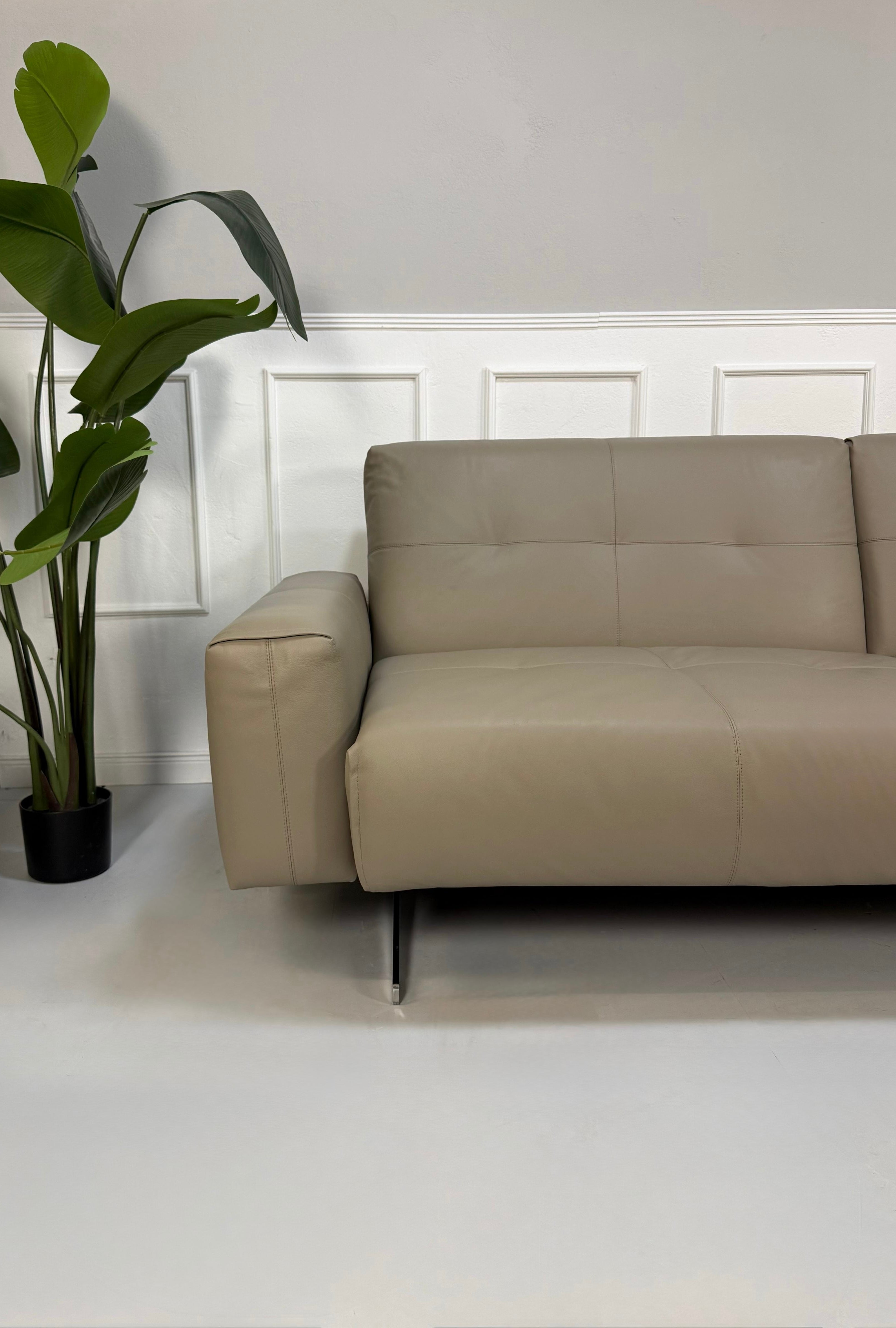 Gebrauchtes graues Rolf Benz 50 Designer Leder Sofa vor einer Wand, stilvoll und modern eingerichtet.