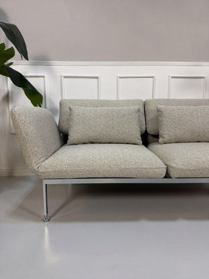 Gebrauchtes graues Brühl Roro Designer Stoff Sofa vor einer Wand, stilvoll und modern eingerichtet.