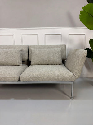 Gebrauchtes graues Brühl Roro Designer Stoff Sofa vor einer Wand, stilvoll und modern eingerichtet.