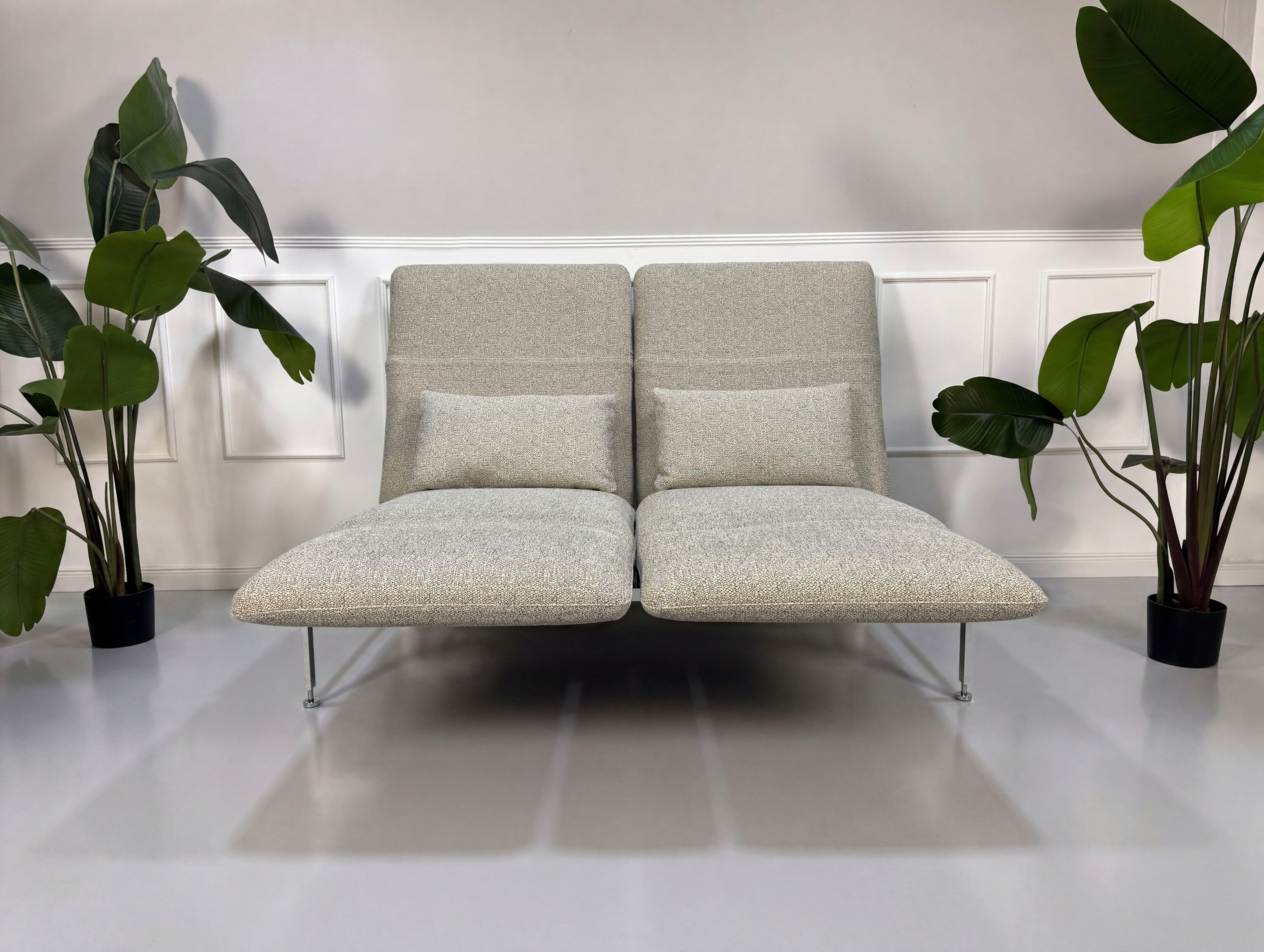 Gebrauchtes graues Brühl Roro Designer Stoff Sofa vor einer Wand, stilvoll und modern eingerichtet.