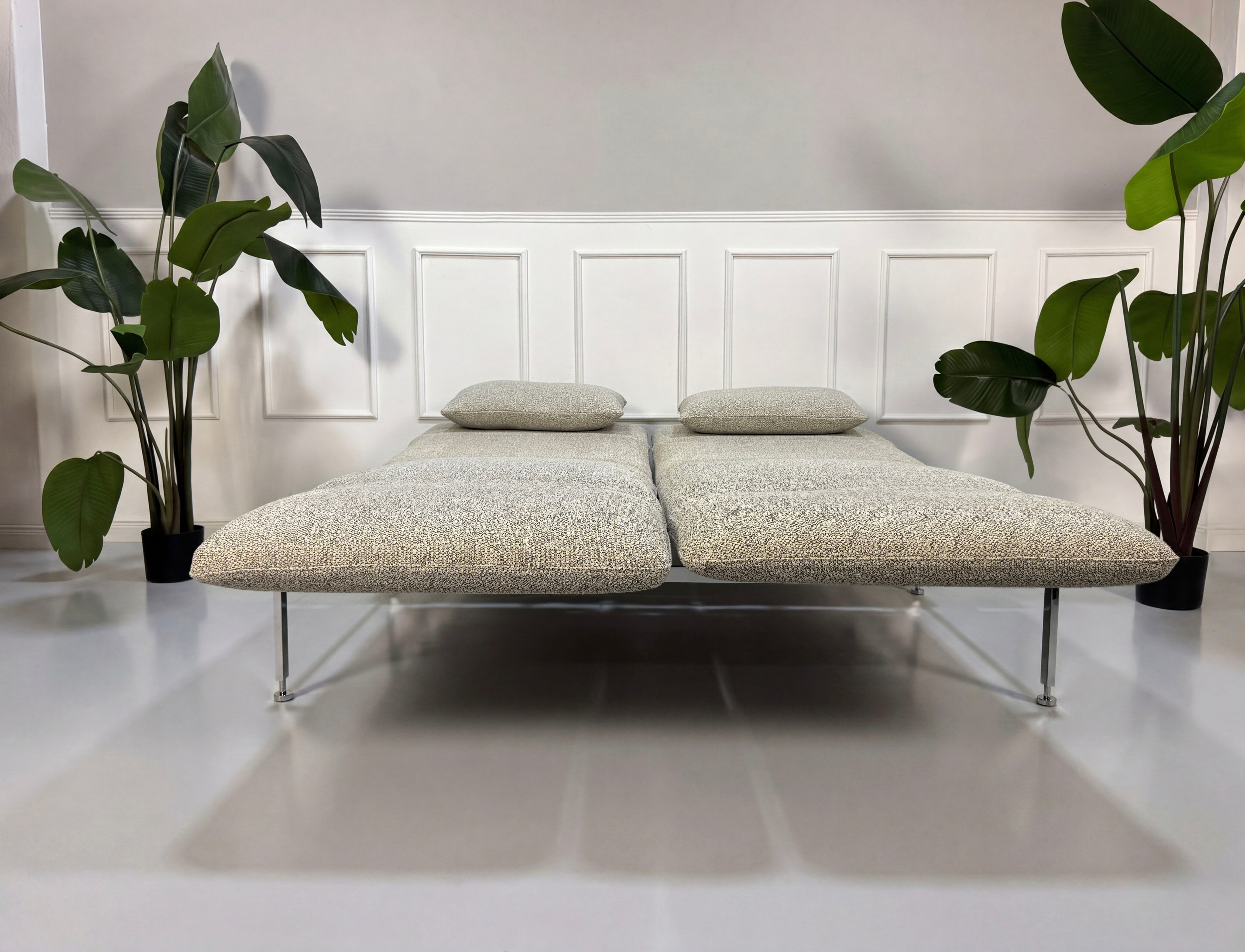 Gebrauchtes graues Brühl Roro Designer Stoff Sofa vor einer Wand, stilvoll und modern eingerichtet.
