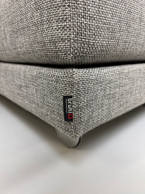 Gebrauchtes graues Brühl Four Two Designer Stoff Sofa vor einer Wand, stilvoll und modern eingerichtet.