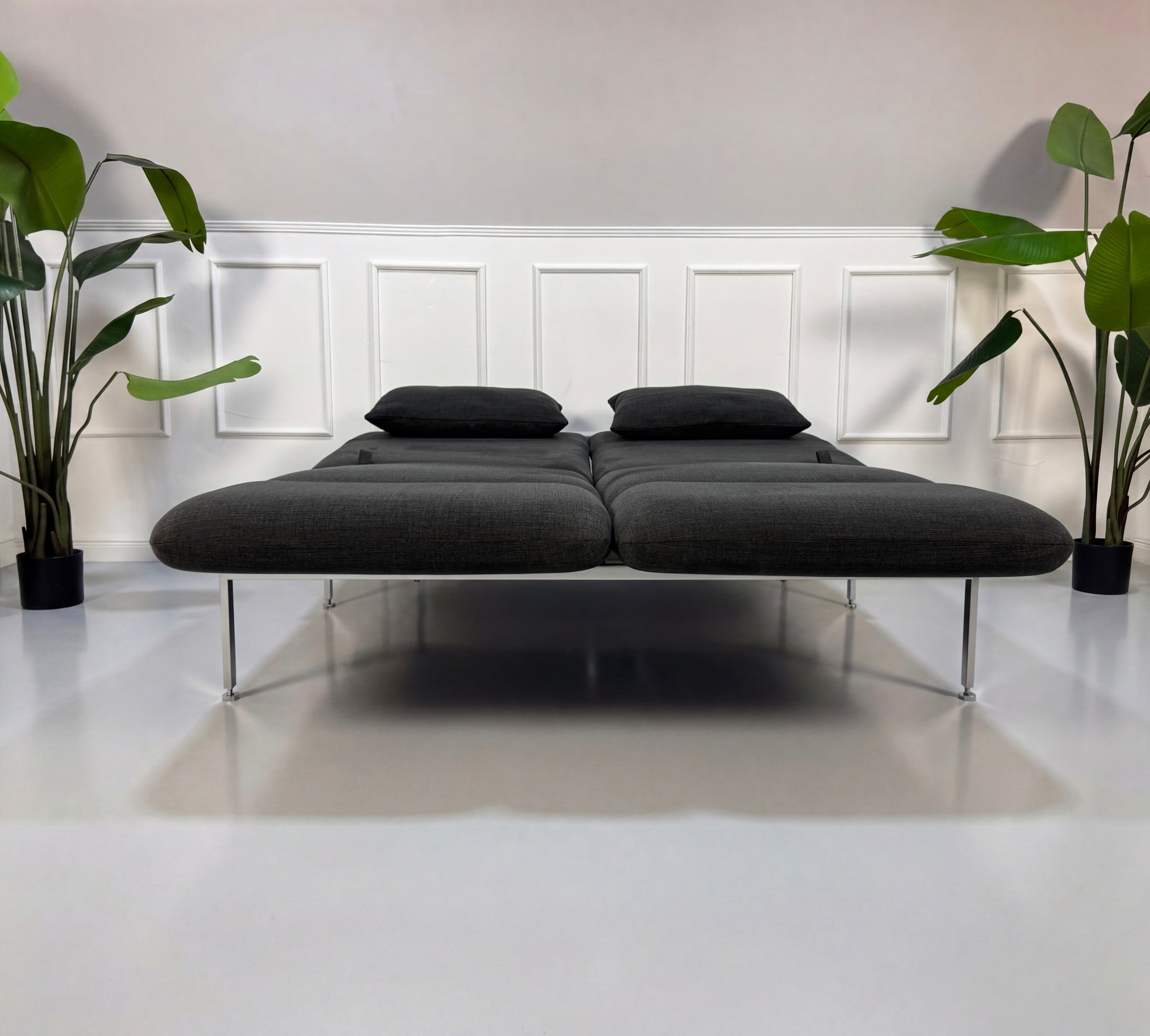 Gebrauchtes graues Brühl Roro Designer Stoff Sofa vor einer Wand, stilvoll und modern eingerichtet.