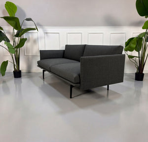 Gebrauchtes graues Muuto Outline Designer Stoff Sofa vor einer Wand, stilvoll und modern eingerichtet.
