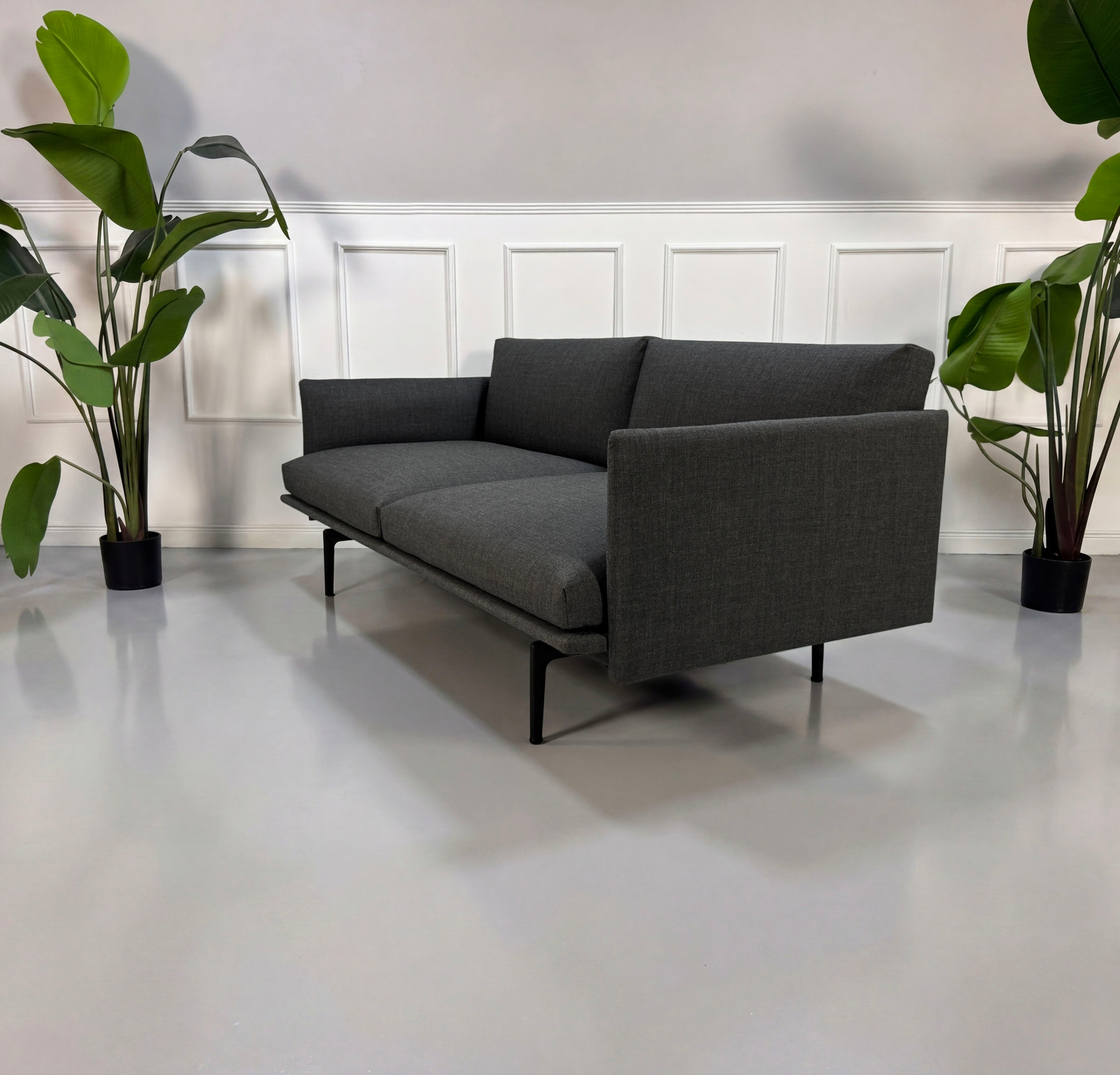 Gebrauchtes graues Muuto Outline Designer Stoff Sofa vor einer Wand, stilvoll und modern eingerichtet.