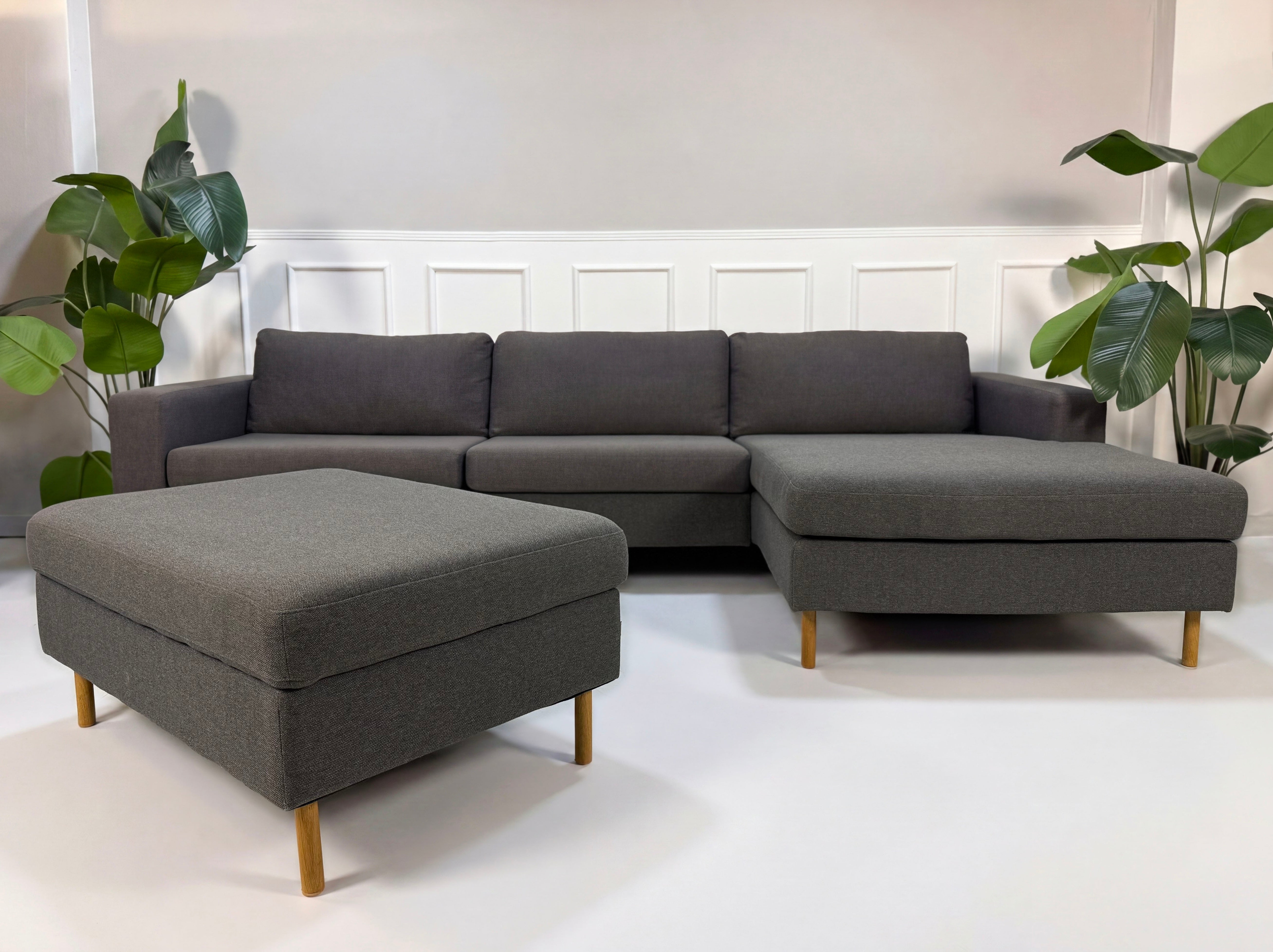 Gebrauchtes graues Bolia Scandinavia Designer Stoff Sofa vor einer Wand, stilvoll und modern eingerichtet.

