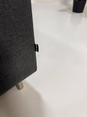 Gebrauchtes graues Bolia Scandinavia Designer Stoff Sofa vor einer Wand, stilvoll und modern eingerichtet.