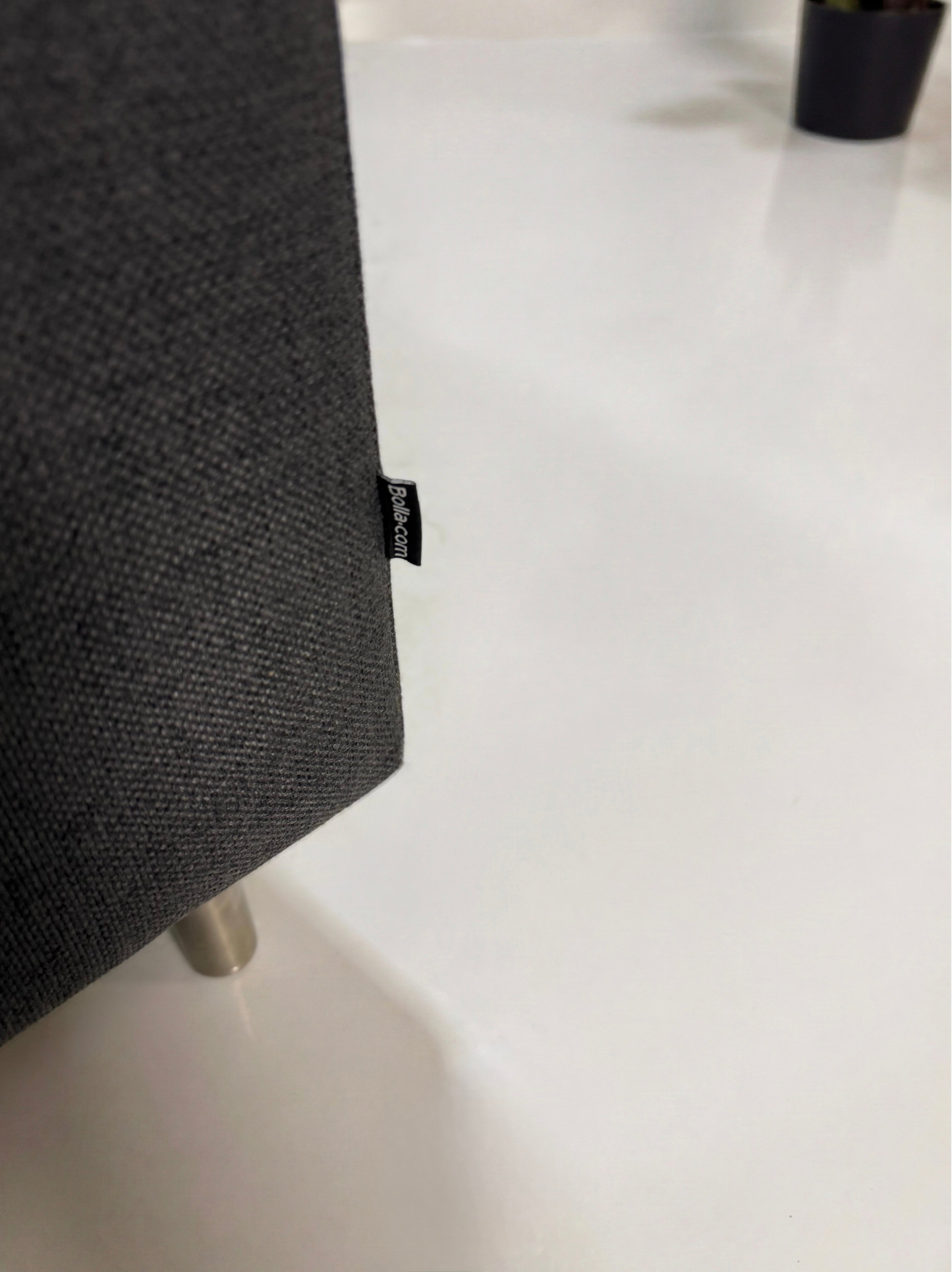 Gebrauchtes graues Bolia Scandinavia Designer Stoff Sofa vor einer Wand, stilvoll und modern eingerichtet.