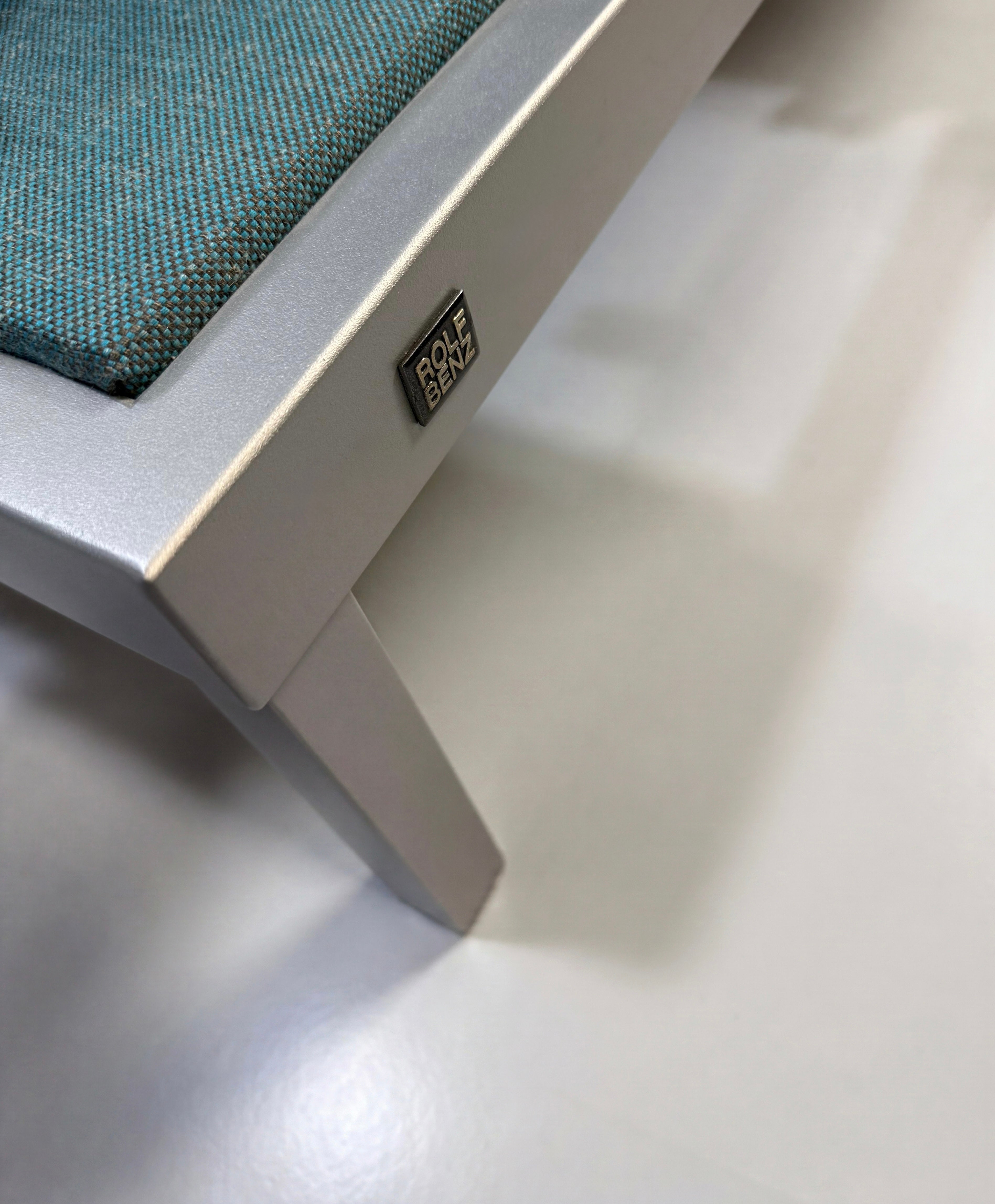 Gebrauchtes blaues Rolf Benz Nova Designer Stoff Sofa vor einer Wand, stilvoll und modern eingerichtet.
