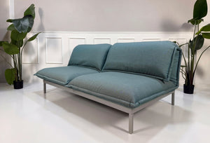 Gebrauchtes blaues Rolf Benz Nova Designer Stoff Sofa vor einer Wand, stilvoll und modern eingerichtet.