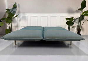 Gebrauchtes blaues Rolf Benz Nova Designer Stoff Sofa vor einer Wand, stilvoll und modern eingerichtet.