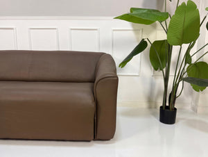 Gebrauchtes braunes DeSede DS47 Designer Leder Sofa vor einer Wand, stilvoll und modern eingerichtet.