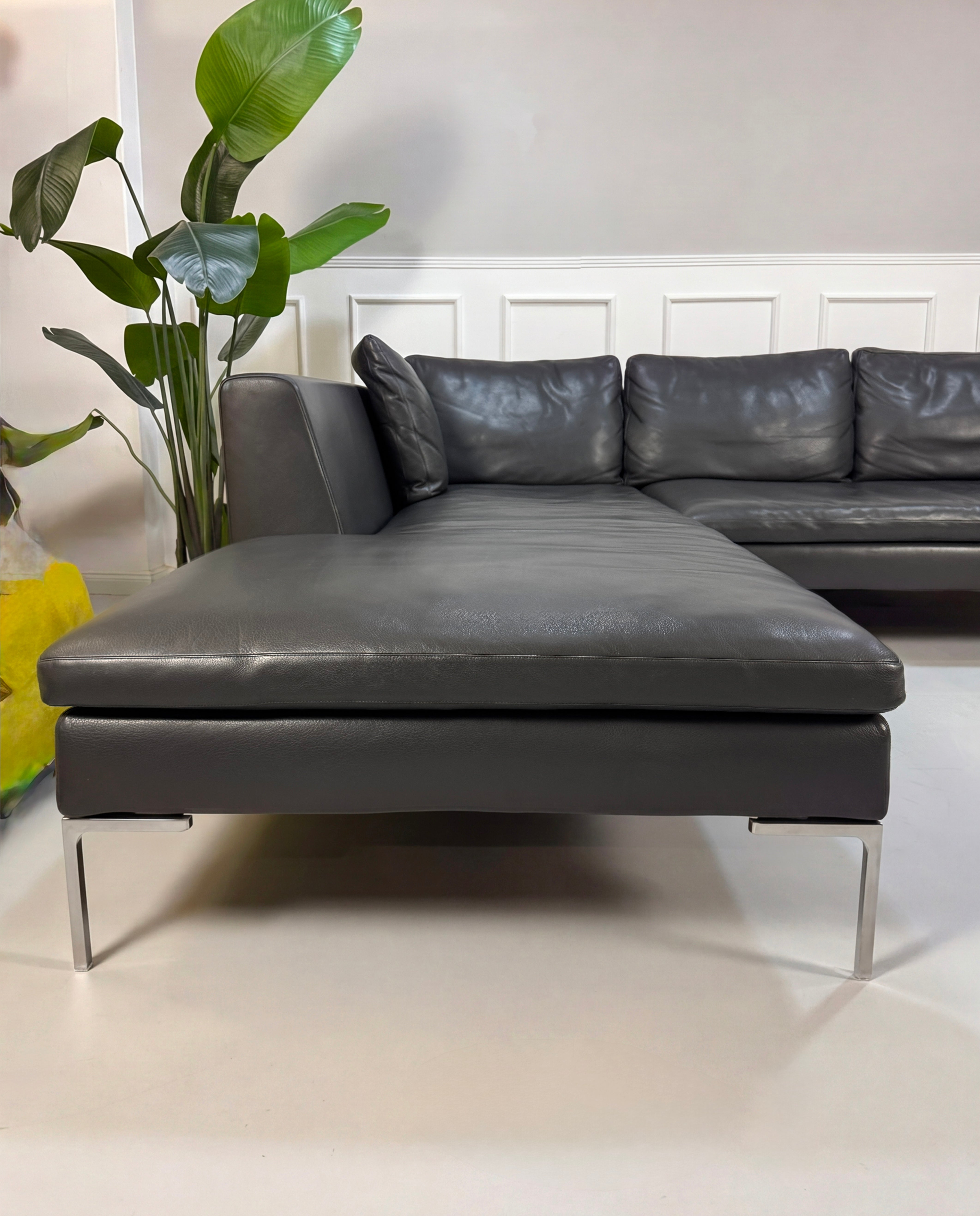 Gebrauchtes graues B&B Italia Charles Designer Leder Sofa vor einer Wand, stilvoll und modern eingerichtet.