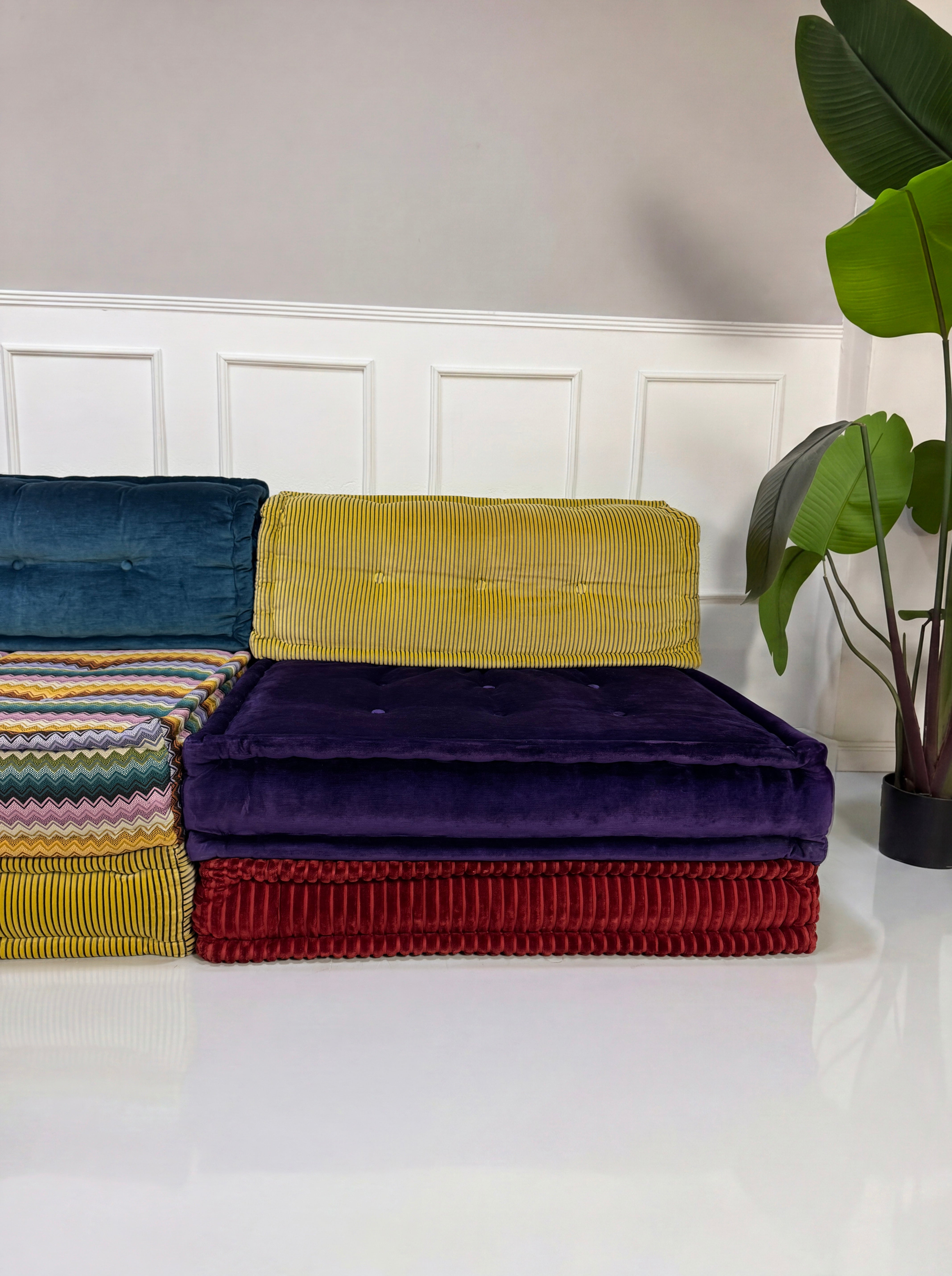 Gebrauchtes buntes Roche Bobois Mah Jong Designer Stoff Sofa vor einer Wand, stilvoll und modern eingerichtet.