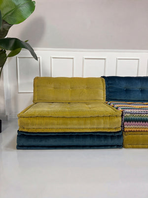 Gebrauchtes buntes Roche Bobois Mah Jong Designer Stoff Sofa vor einer Wand, stilvoll und modern eingerichtet.