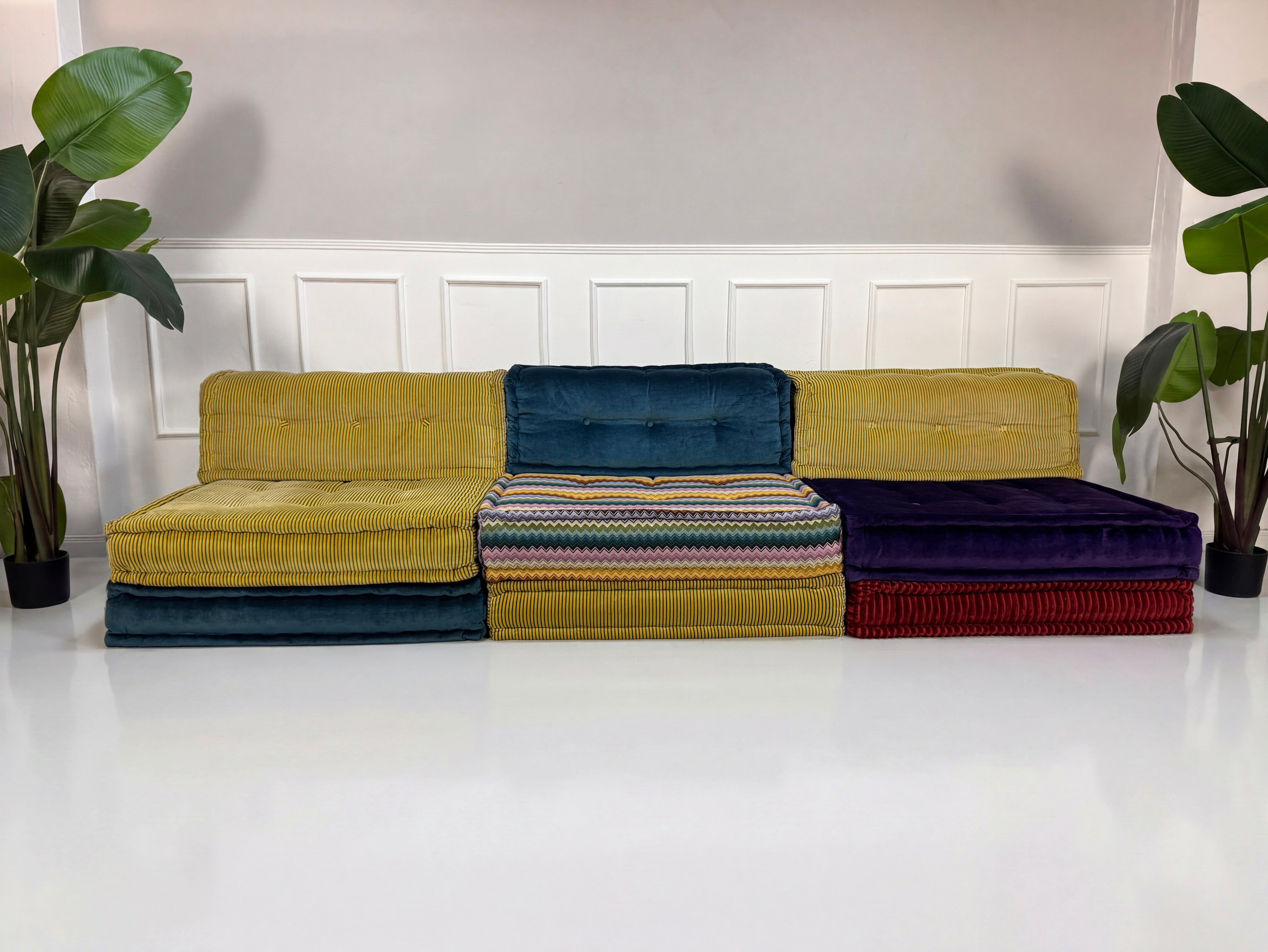 Gebrauchtes buntes Roche Bobois Mah Jong Designer Stoff Sofa vor einer Wand, stilvoll und modern eingerichtet.