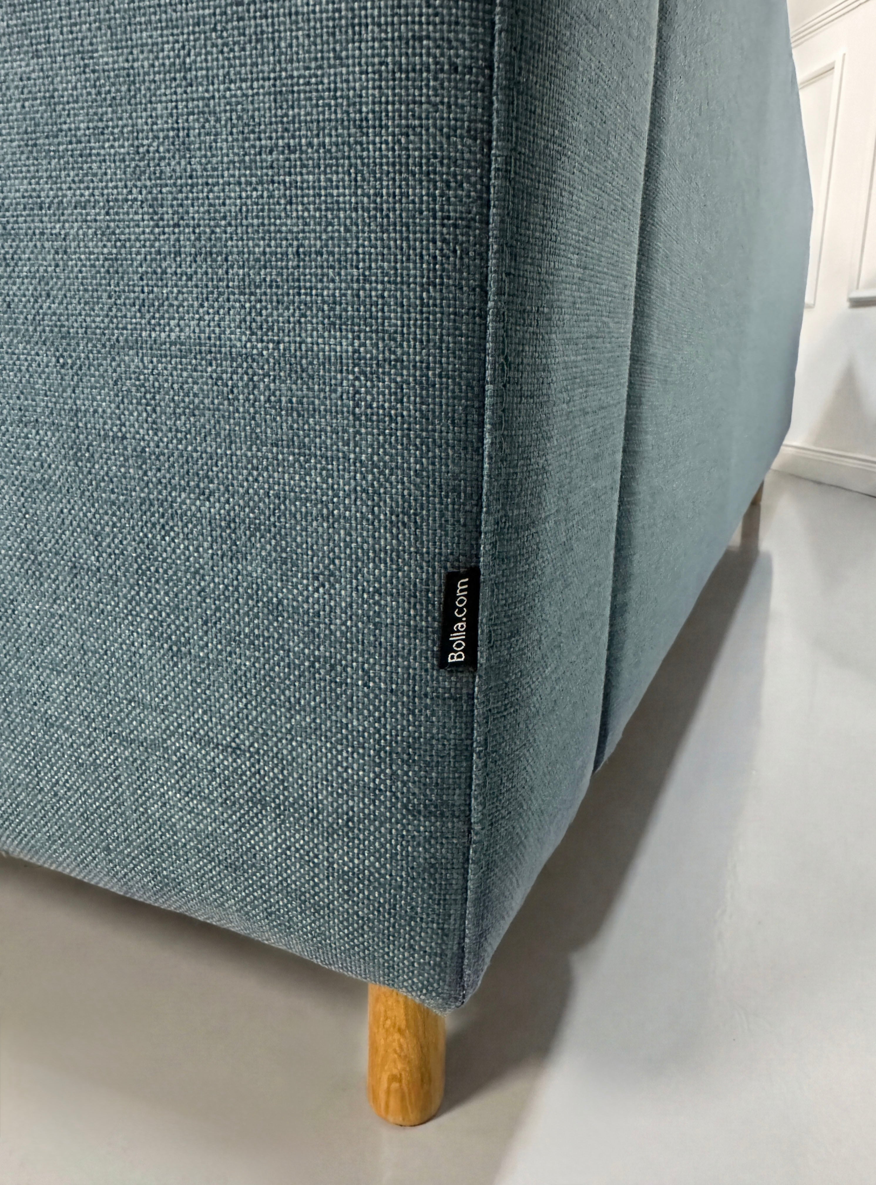 Gebrauchtes blaues Bolia Scandinavia Designer Stoff Sofa vor einer Wand, stilvoll und modern eingerichtet.
