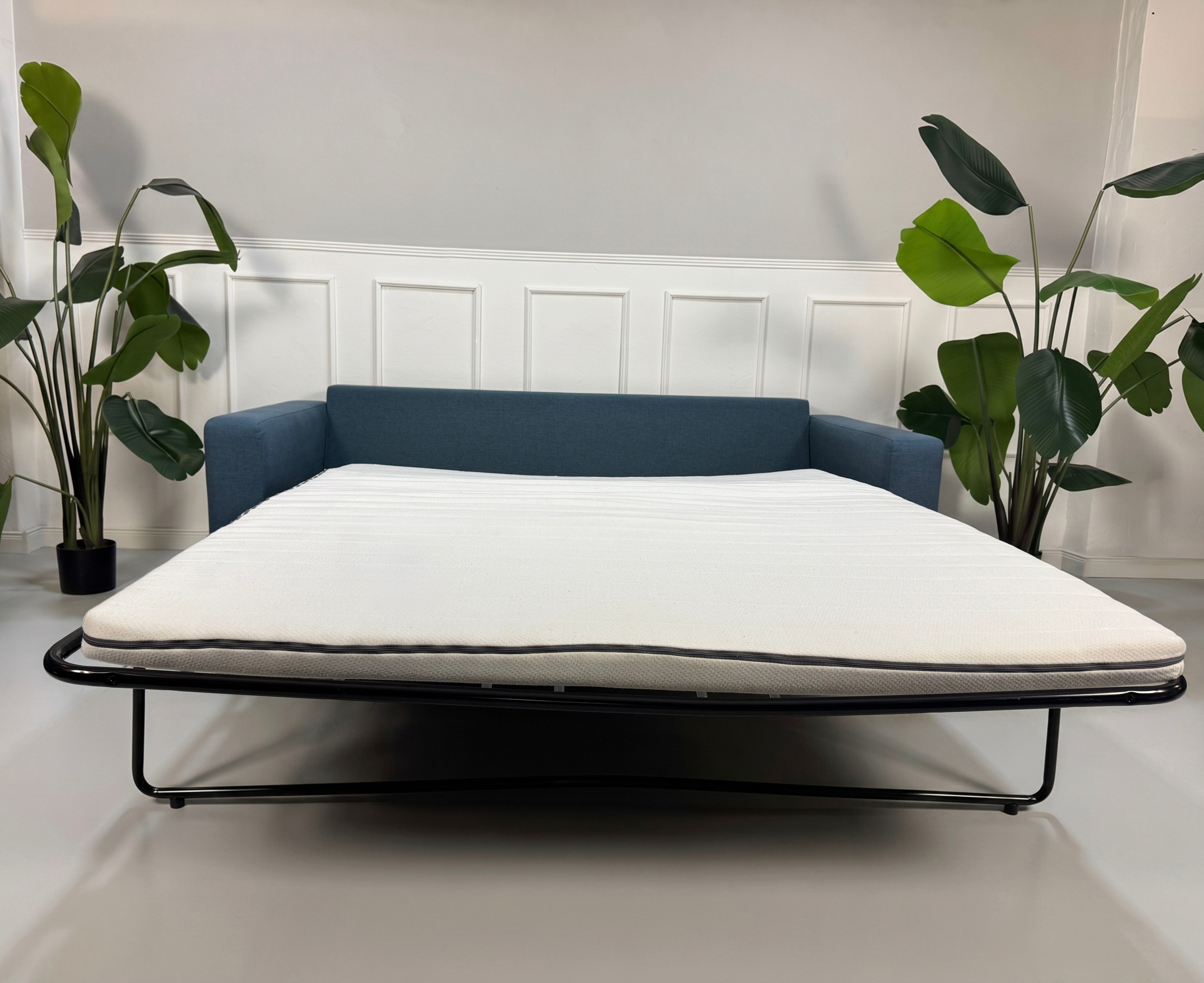 Gebrauchtes blaues Bolia Scandinavia Designer Stoff Sofa vor einer Wand, stilvoll und modern eingerichtet.