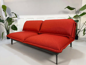 Gebrauchtes orange Rolf Benz Nova Designer Stoff Sofa vor einer Wand, stilvoll und modern eingerichtet.