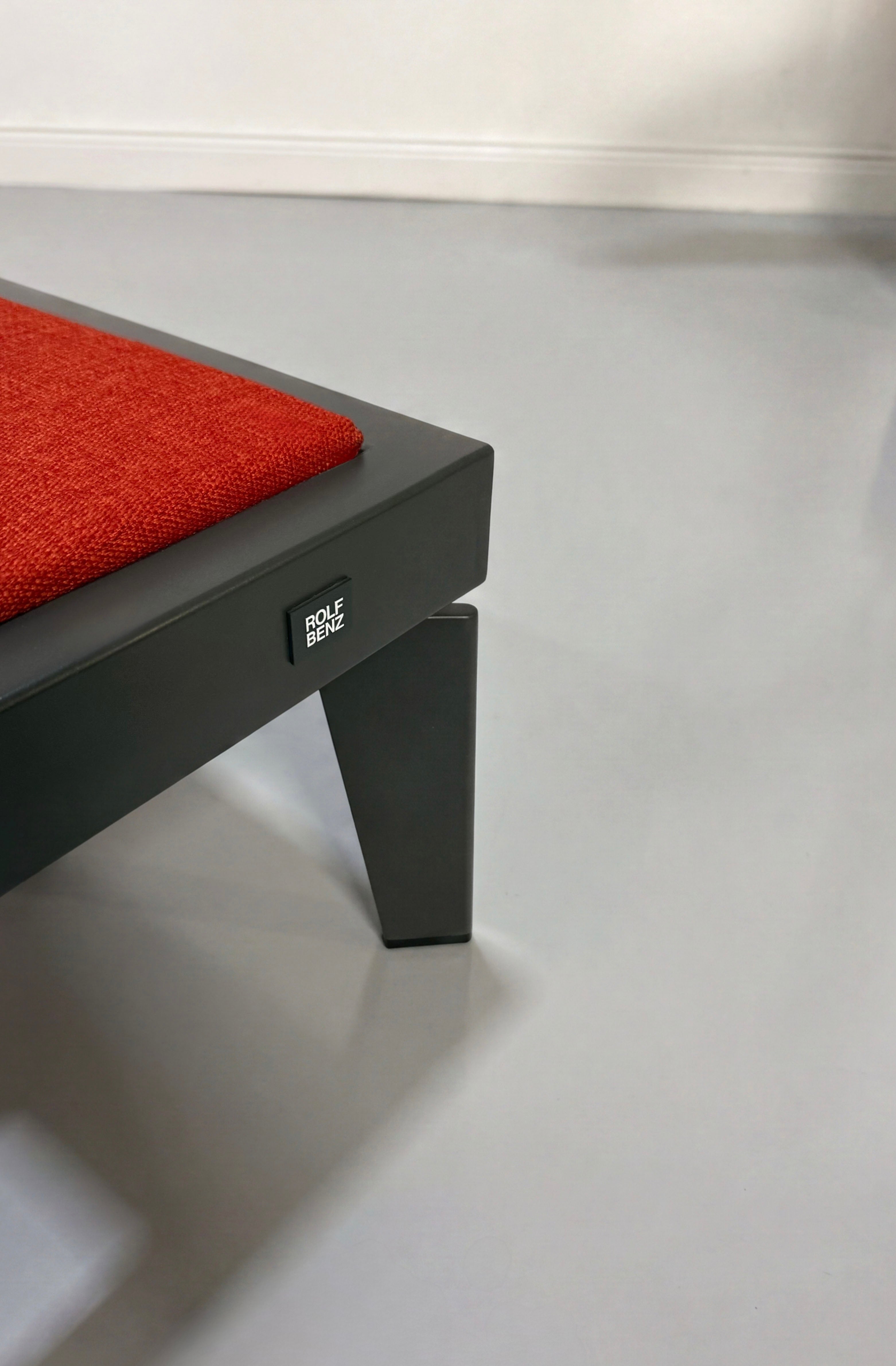 Gebrauchtes orange Rolf Benz Nova Designer Stoff Sofa vor einer Wand, stilvoll und modern eingerichtet.