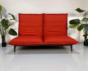 Gebrauchtes orange Rolf Benz Nova Designer Stoff Sofa vor einer Wand, stilvoll und modern eingerichtet.