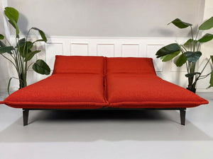 Gebrauchtes orange Rolf Benz Nova Designer Stoff Sofa vor einer Wand, stilvoll und modern eingerichtet.