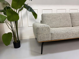 Gebrauchtes graues Koinor Hiero Designer Stoff Sofa vor einer Wand, stilvoll und modern eingerichtet.