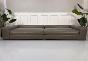 Refurbished Minotti Jagger Designer Leder Sofa vor einer Wand, stilvoll und modern eingerichtet.