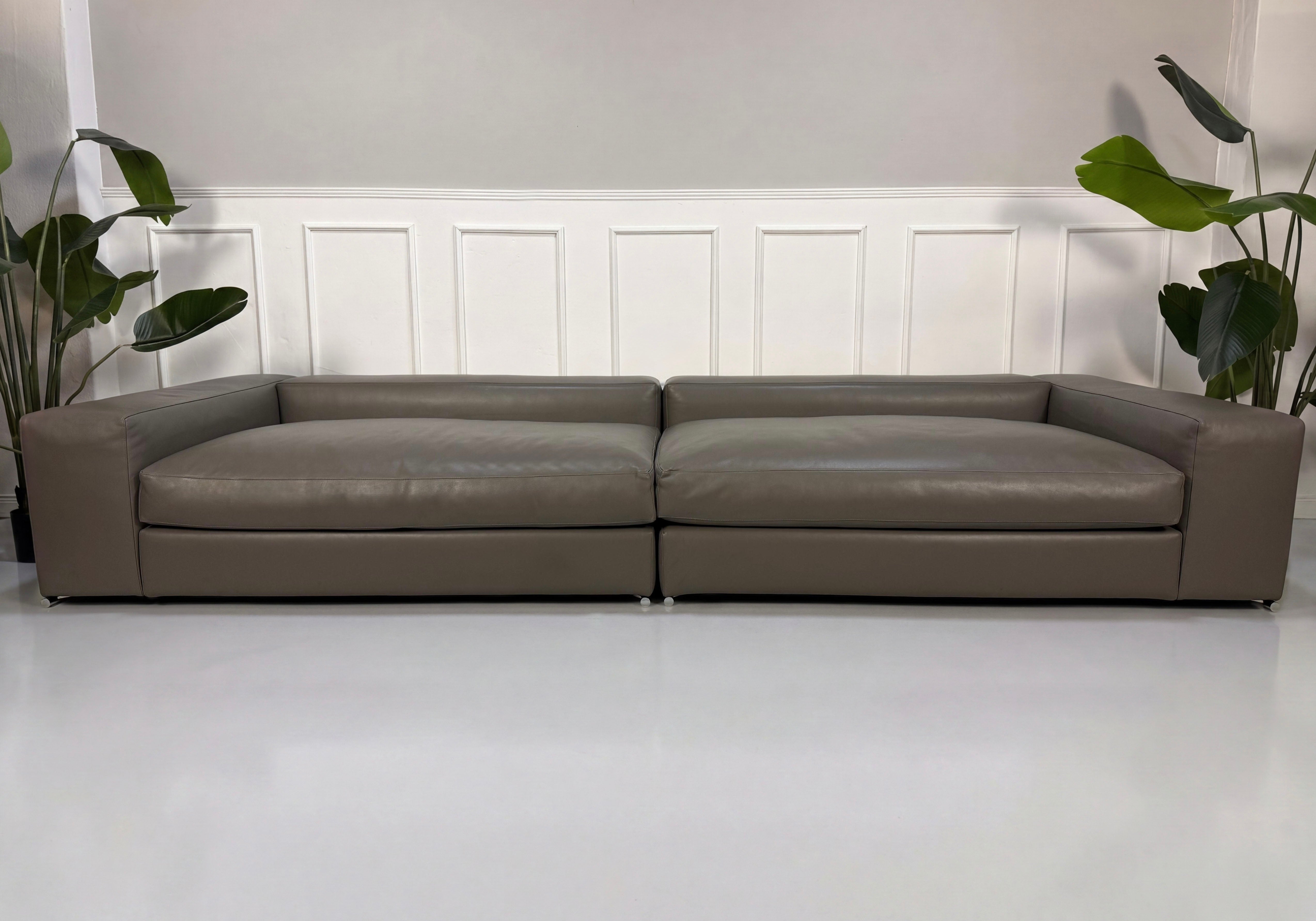 Refurbished Minotti Jagger Designer Leder Sofa vor einer Wand, stilvoll und modern eingerichtet.