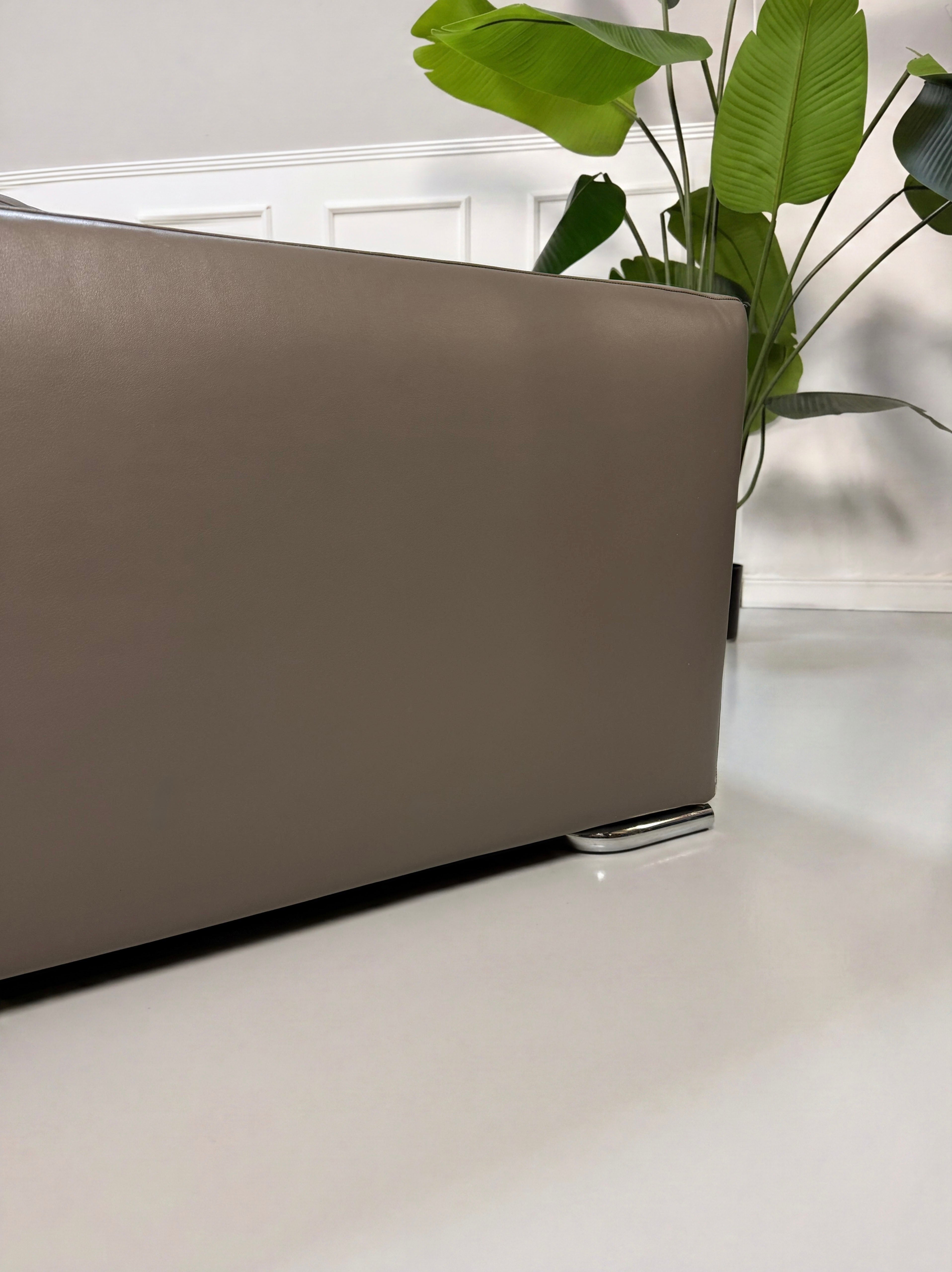 Refurbished Minotti Jagger Designer Leder Sofa vor einer Wand, stilvoll und modern eingerichtet.