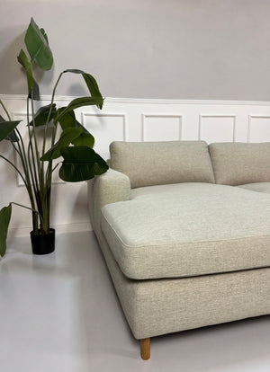 Gebrauchtes grau sand Bolia Scandinavia Designer Stoff Sofa vor einer Wand, stilvoll und modern eingerichtet.