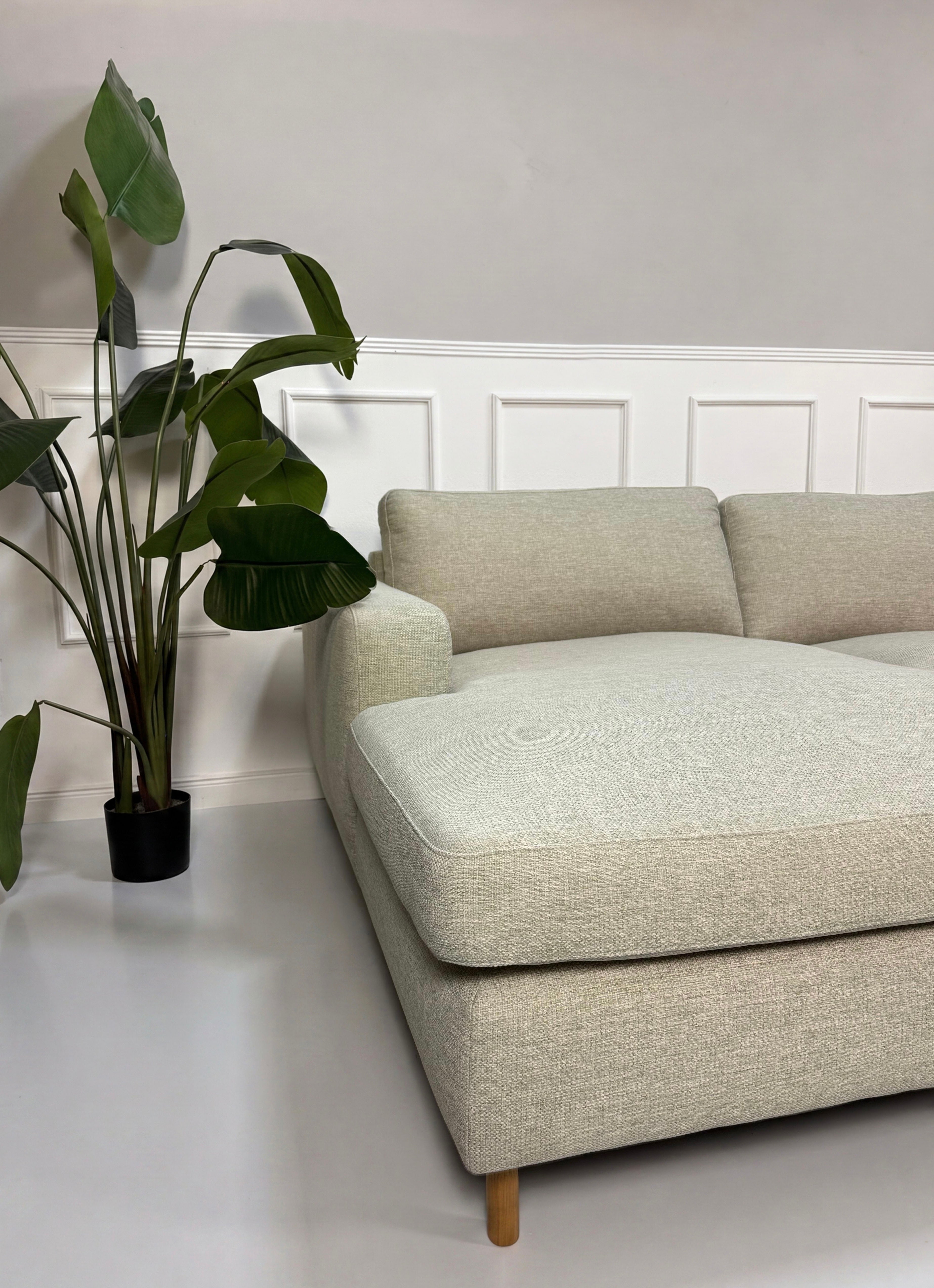 Gebrauchtes grau sand Bolia Scandinavia Designer Stoff Sofa vor einer Wand, stilvoll und modern eingerichtet.