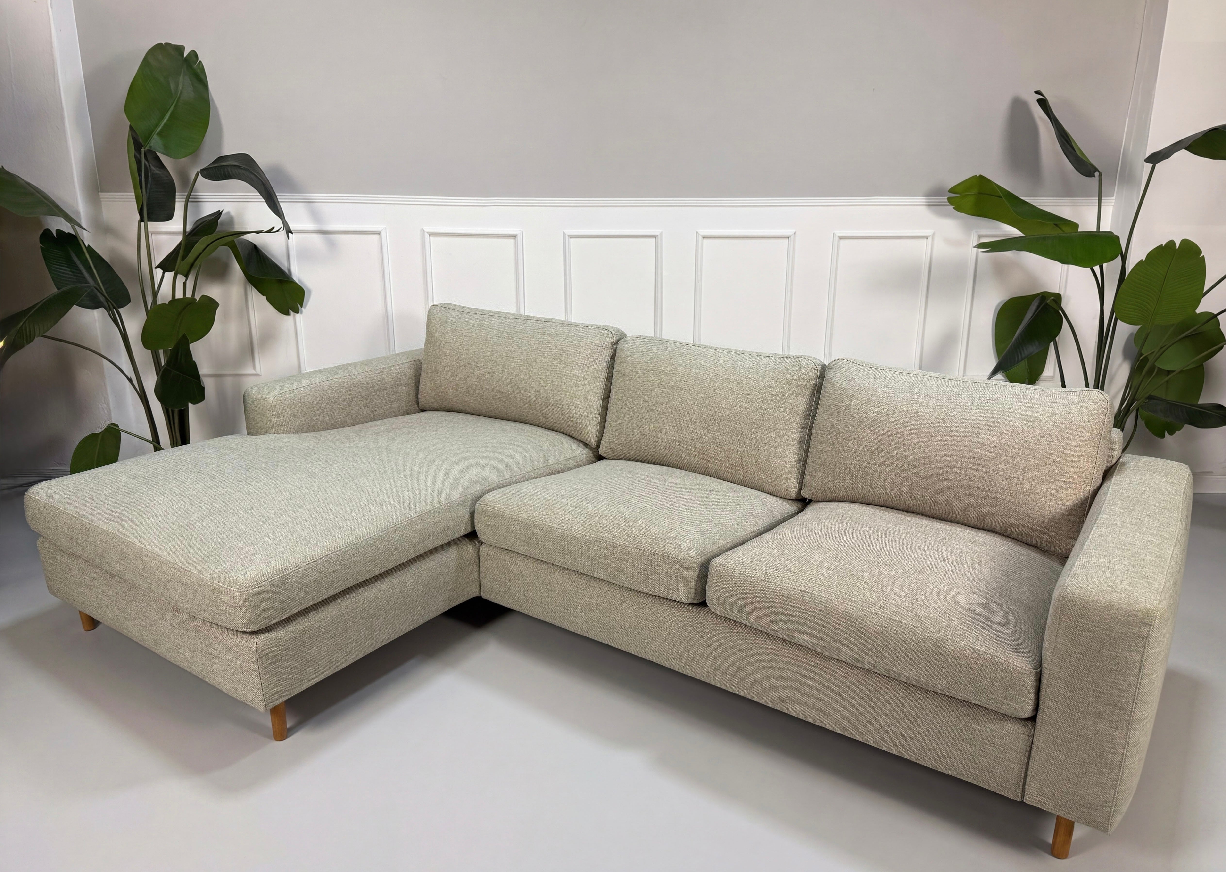 Gebrauchtes grau sand Bolia Scandinavia Designer Stoff Sofa vor einer Wand, stilvoll und modern eingerichtet.