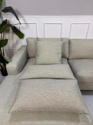 Gebrauchtes grau sand Bolia Scandinavia Designer Stoff Sofa vor einer Wand, stilvoll und modern eingerichtet.