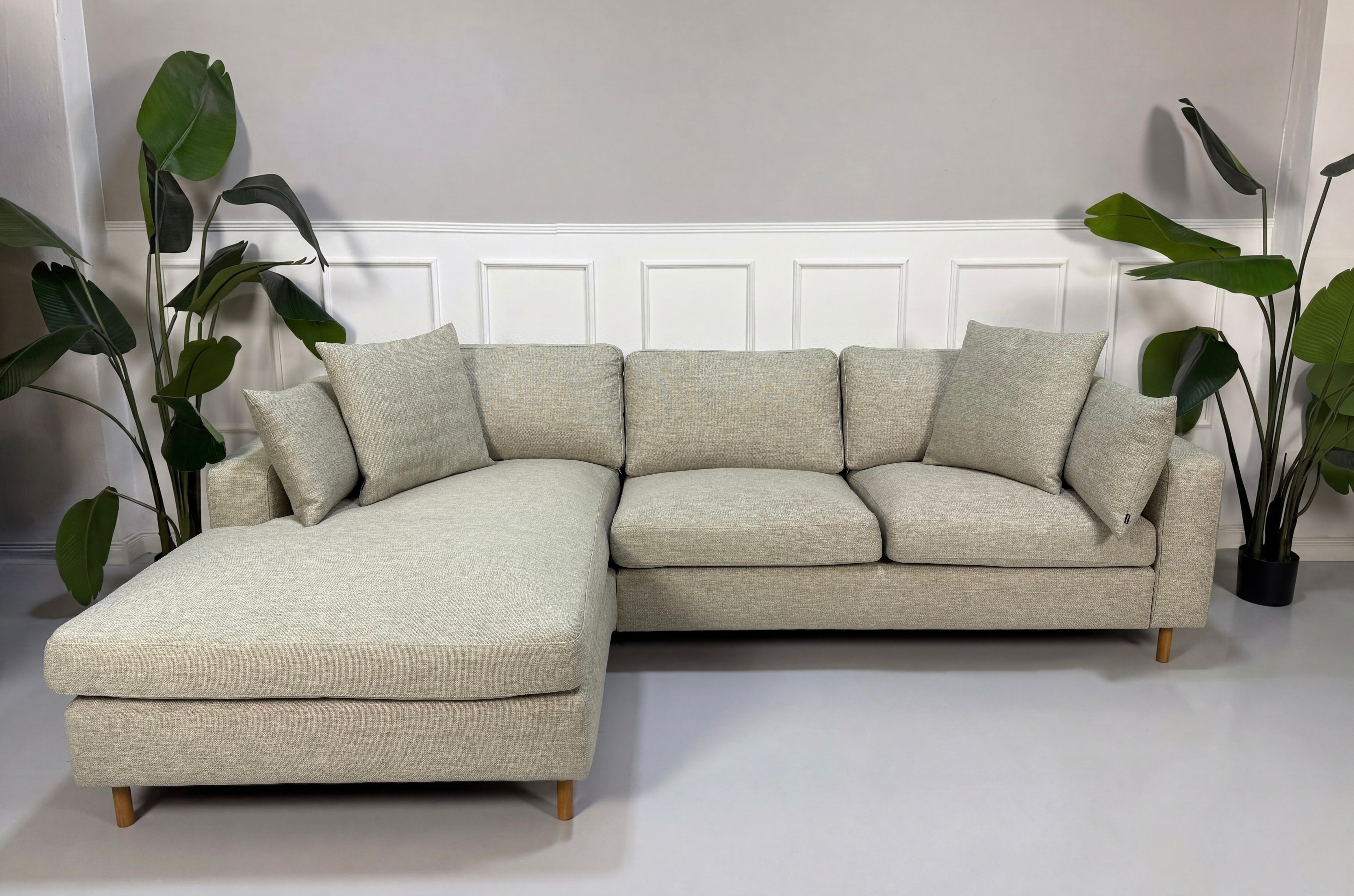 Gebrauchtes grau sand Bolia Scandinavia Designer Stoff Sofa vor einer Wand, stilvoll und modern eingerichtet.
