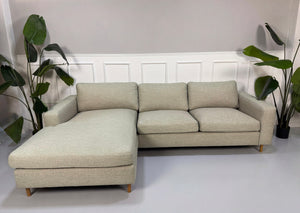 Gebrauchtes grau sand Bolia Scandinavia Designer Stoff Sofa vor einer Wand, stilvoll und modern eingerichtet.