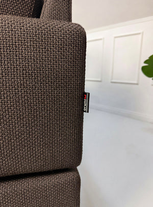 Gebrauchtes braunes Brühl Ecksofa Designer Stoff Sofa vor einer Wand, stilvoll und modern eingerichtet.