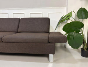 Gebrauchtes braunes Brühl Ecksofa Designer Stoff Sofa vor einer Wand, stilvoll und modern eingerichtet.