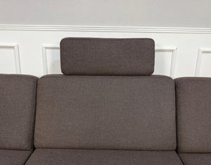 Gebrauchtes braunes Brühl Ecksofa Designer Stoff Sofa vor einer Wand, stilvoll und modern eingerichtet.