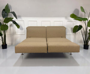 Gebrauchtes beiges Brühl Moule Designer Stoff Sofa vor einer Wand, stilvoll und modern eingerichtet.
