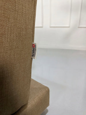 Gebrauchtes beiges Brühl Moule Designer Stoff Sofa vor einer Wand, stilvoll und modern eingerichtet.