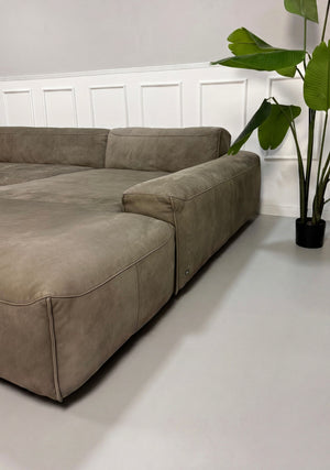 Gebrauchtes braunes Rolf Benz Mio Designer Leder Sofa vor einer Wand, stilvoll und modern eingerichtet.
