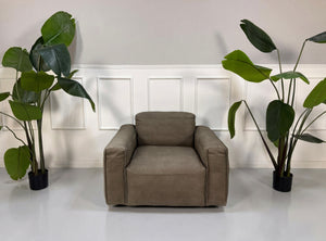 Gebrauchter braunen Rolf Benz Mio  Designer Leder Sessel vor einer Wand, stilvoll und modern eingerichtet.

