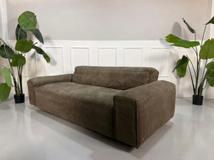 Gebrauchtes braunes Rolf Benz Mio Designer Leder Sofa vor einer Wand, stilvoll und modern eingerichtet.