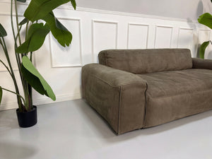 Gebrauchtes braunes Rolf Benz Mio Designer Leder Sofa vor einer Wand, stilvoll und modern eingerichtet.